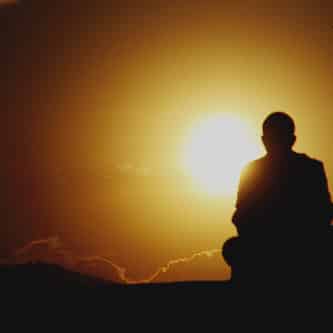 man sitting in sunset practicing self awareness